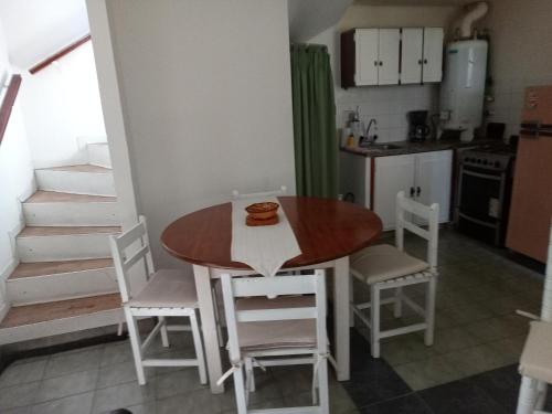 cocina y comedor con mesa y sillas en Lo de Normi en Tandil