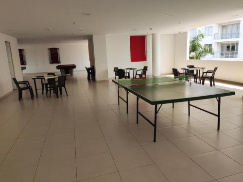 a room with ping pong tables and chairs in it at Hermoso apartamento con piscina (alberca). in Girardot