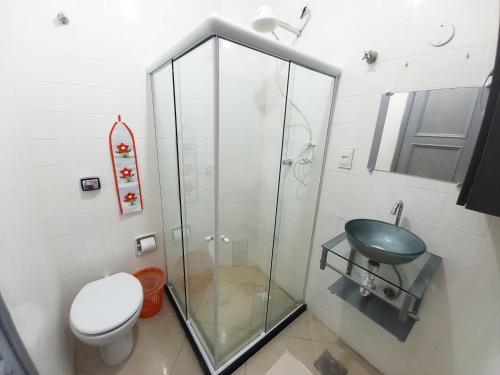 y baño con ducha de cristal y aseo. en Loft na Praia de Copacabana, maquina de lavar, en Río de Janeiro