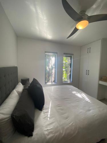a bedroom with a large bed with a ceiling fan at The Bridge UNIT 23 St Lucia in St Lucia