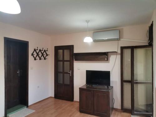 una sala de estar con TV y una habitación con puerta en Quiet central studio en Pazardzhik