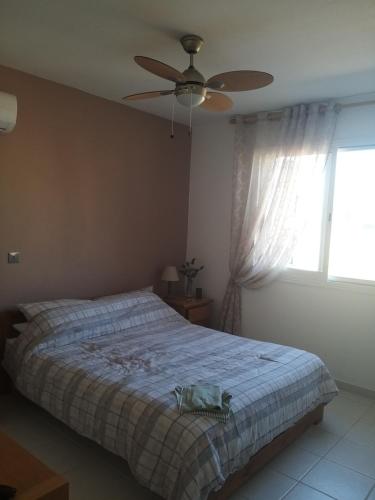 um quarto com uma cama e uma ventoinha de tecto em Tala Gardens Apartment em Tala