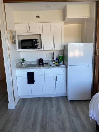 a kitchen with white cabinets and a white refrigerator at Charming Micro studio in Gadsden, AL in Gadsden