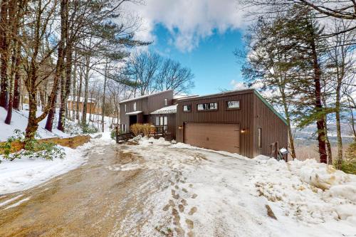 a house with a garage in the snow at Amazing View Retreat Home in Campton