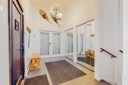 un corridoio con pareti bianche e lampadario a braccio di Amazing View Retreat Home a Campton