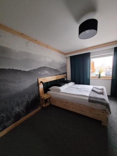 sypialnia z łóżkiem z obrazem na ścianie w obiekcie Karolowy pokoje&apartamenty w Ustroniu