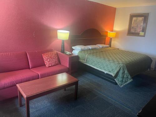 a hotel room with a couch and a bed at Economy Inn Little Rock in Little Rock