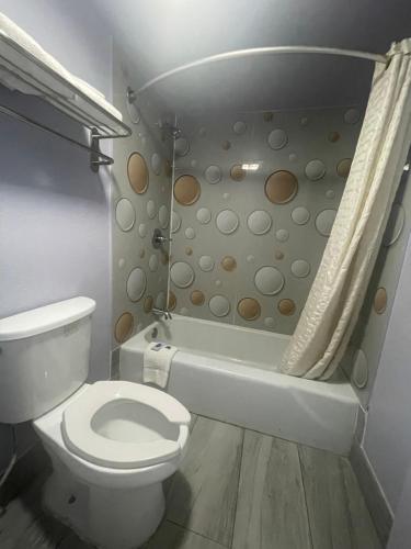 een badkamer met een toilet, een douche en een bad bij Economy Inn Little Rock in Little Rock