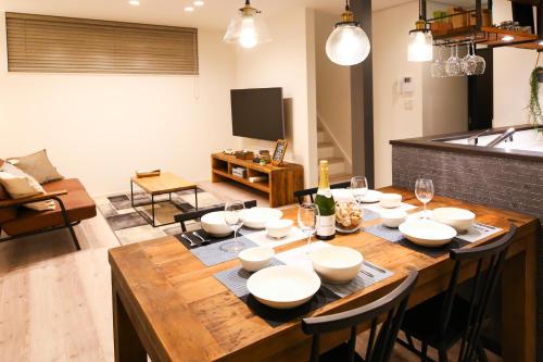 a dining room with a wooden table with white bowls at TEINE WHITE HOUSE in Sapporo