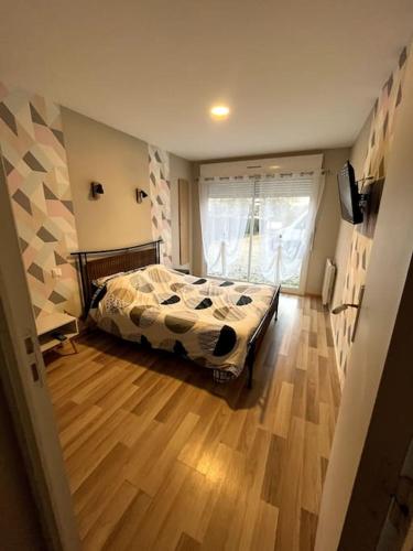 une chambre avec un lit et un parquet dans l'établissement Gîte équipé 1 à 8 personnes modulable lire hôte, à Montfarville