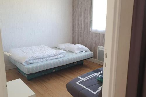 a small bedroom with a bed and a window at Gîte équipé 1 à 8 personnes modulable lire hôte in Montfarville