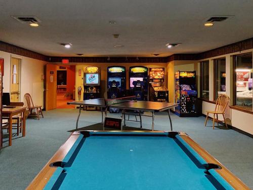 a billiard room with a pool table and two tables at Cathedral Ledge Resort in North Conway
