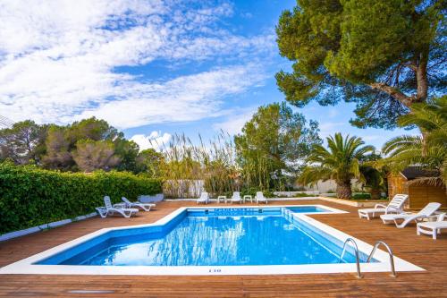 una piscina con tumbonas y una piscina en Viviendas turísticas Lesley VTV Es Pi - Formentera Break, en Playa de Migjorn