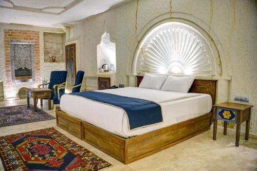 um quarto com uma cama grande e uma janela arqueada em Cappadocia Sweet Cave Hotel em Nevşehir