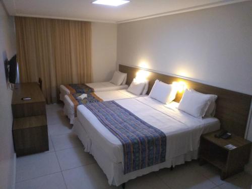 a hotel room with two beds with lights on them at Hotel Pousada do Sol in Aracaju