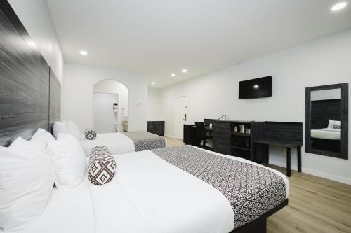 a hotel room with two beds and a television at Sapphire Inn & Suites in Deer Park
