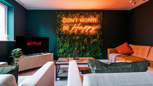 a living room with a sign that says dont worry be happy at Wharf View Townhouse Chester in Chester