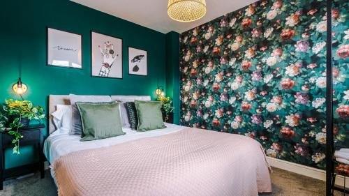 a bedroom with a bed with a floral wall at Wharf View Townhouse Chester in Chester