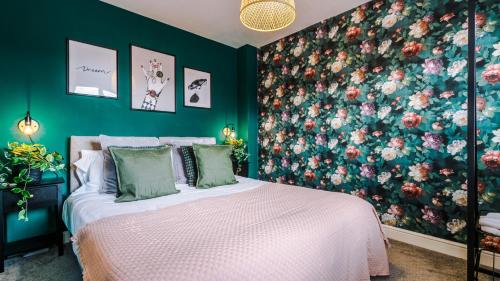 a bedroom with a bed with a floral wall at Wharf View Townhouse Chester in Chester