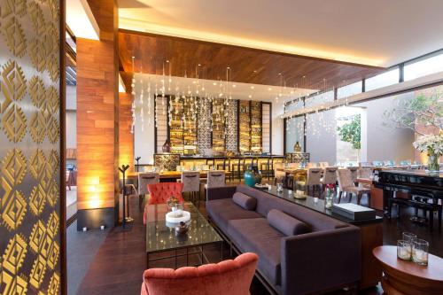 a lobby of a restaurant with a couch and a bar at JW Marriott Los Cabos Beach Resort & Spa in San José del Cabo