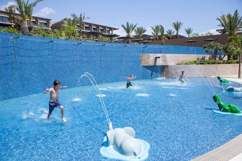 a group of people playing in a water park at JW Marriott Los Cabos Beach Resort & Spa in San José del Cabo