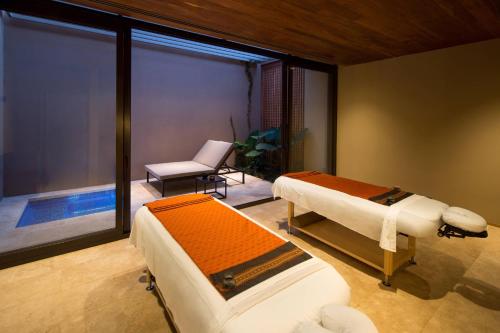 a room with two beds and a chair and a window at JW Marriott Los Cabos Beach Resort & Spa in San José del Cabo
