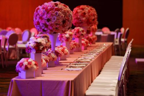 a row of tables with purple and pink flowers on them at JW Marriott Los Cabos Beach Resort & Spa in San José del Cabo