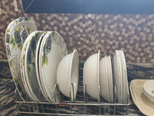 a rack of plates and bowls on a counter at Hotel Taj Bi Plaza in Aurangabad