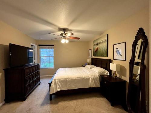 Schlafzimmer mit einem Bett und einem Deckenventilator in der Unterkunft Cozy 3-bed Garden Home - 10 mins to UT Stadium and Downtown Austin in Austin