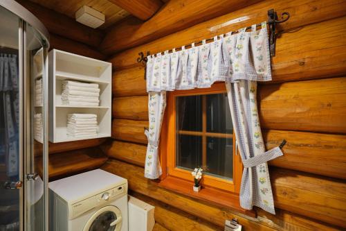 a bathroom with a washer and a window in a log cabin at Mia Bella luxury chalet in Slovenske Konjice in Slovenske Konjice