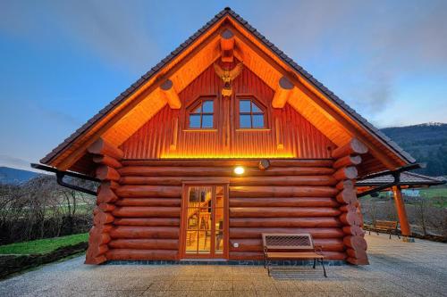 uma cabana de madeira com um banco à frente em Mia Bella luxury chalet in Slovenske Konjice em Slovenske Konjice