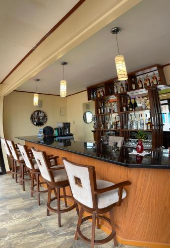 a bar in a restaurant with chairs and a counter at Foxy's Beach Resort in San Vicente