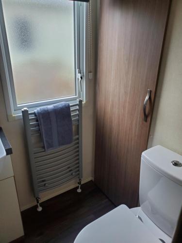 a bathroom with a toilet and a window and a towel at Heysham seaview in Heysham