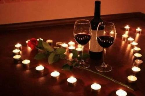 a table with two glasses of wine and candles at Hotel Boutique Spa Villa de Sant in Quito