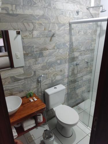 a bathroom with a toilet and a sink and a shower at Pousada Morada do Sol in Camocim