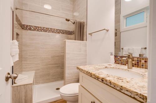 a bathroom with a sink and a toilet and a shower at Unit 12 Maui Ohana Modern Studio in Wailuku