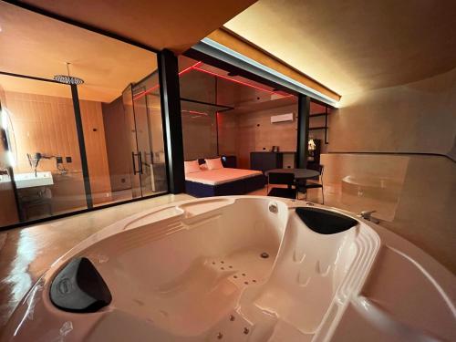 bañera grande en una habitación con dormitorio en Lush Motel Lapa, en São Paulo
