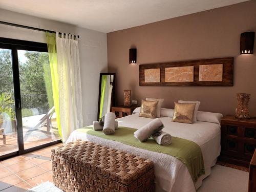 a bedroom with a large bed and a balcony at Sa Bardella in Sant Joan de Labritja