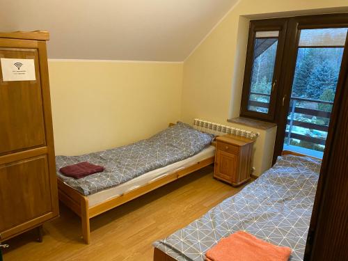 een slaapkamer met 2 aparte bedden en een raam bij Dom Wiktor 