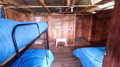 a room with two bunk beds and a white chair at Finca El Encanto del Guejar in Lejanías