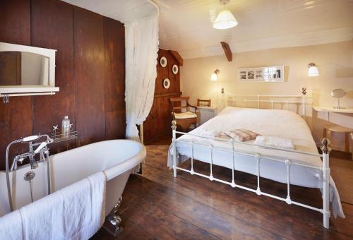 ein Badezimmer mit einer Badewanne, einem Bett und einer Badewanne in der Unterkunft Arwel in New Quay