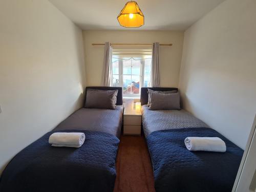 Duas camas num pequeno quarto com uma janela em 2 Cosy Bedrooms in a 3 Bed Home em Tyrrelstown