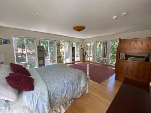 ein Schlafzimmer mit einem großen Bett und einigen Fenstern in der Unterkunft Stunning Guest House Nestled within the Redwoods in Corte Madera