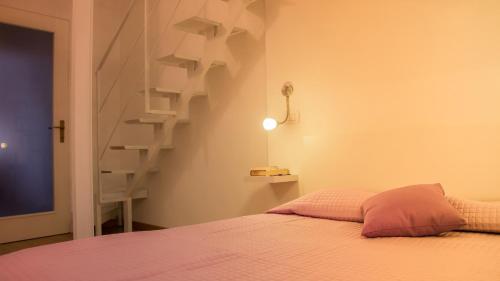 カリアリにあるAppartamento Lilla dei Buoni e Cattiviのベッドルーム1室(ベッド1台付)、螺旋階段