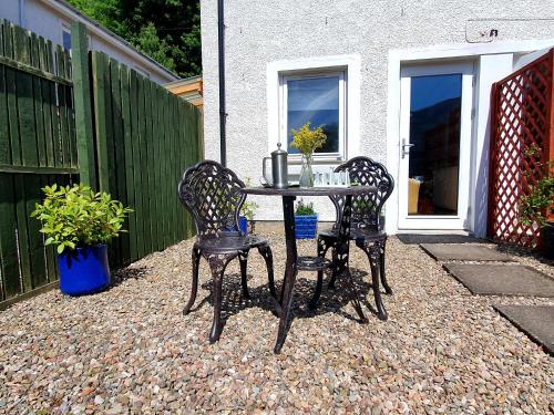 a table and two chairs on a patio at Achray House Restaurant with Rooms in Saint Fillans