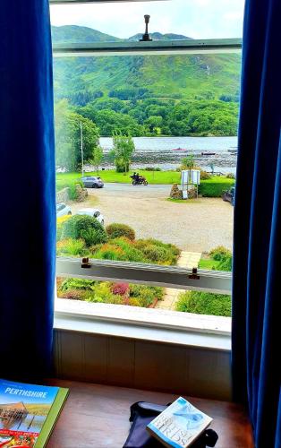 a window with a view of a landscaped yard at Achray House Restaurant with Rooms in Saint Fillans