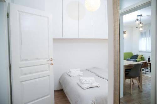een witte slaapkamer met een bed en een eetkamer bij Nusha's place in Zagreb