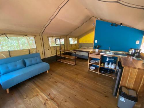 a living room with a blue couch in a trailer at El Pulpo Safari Lodge in Ojochal