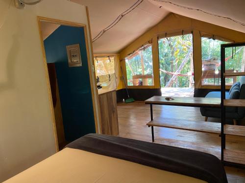 Zimmer mit einem Bett und einem Tisch in einem Zelt in der Unterkunft El Pulpo Safari Lodge in Ojochal