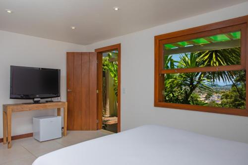 a living room with a tv and a window at O HOTEL in Búzios